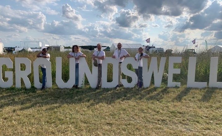 People standing next to large Groundswell sign.