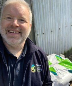 A man standing in front of bags of seed used for supplementary feeding of Turtle Doves